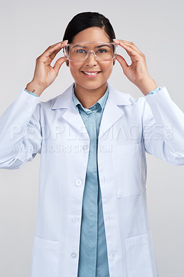 Buy stock photo Cropped portrait of an attractive young female scientist wearing goggles in studio against a grey background