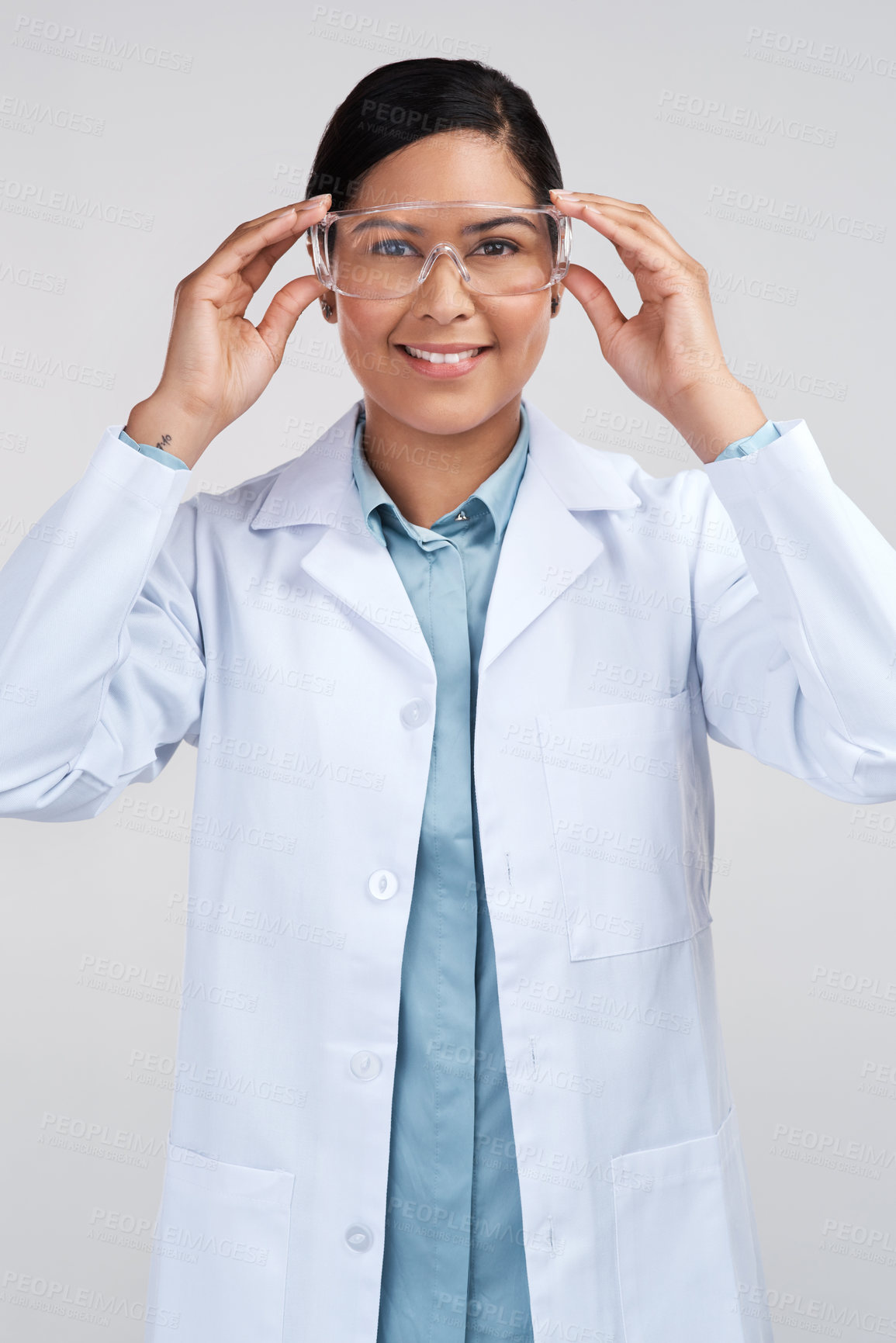 Buy stock photo Cropped portrait of an attractive young female scientist wearing goggles in studio against a grey background