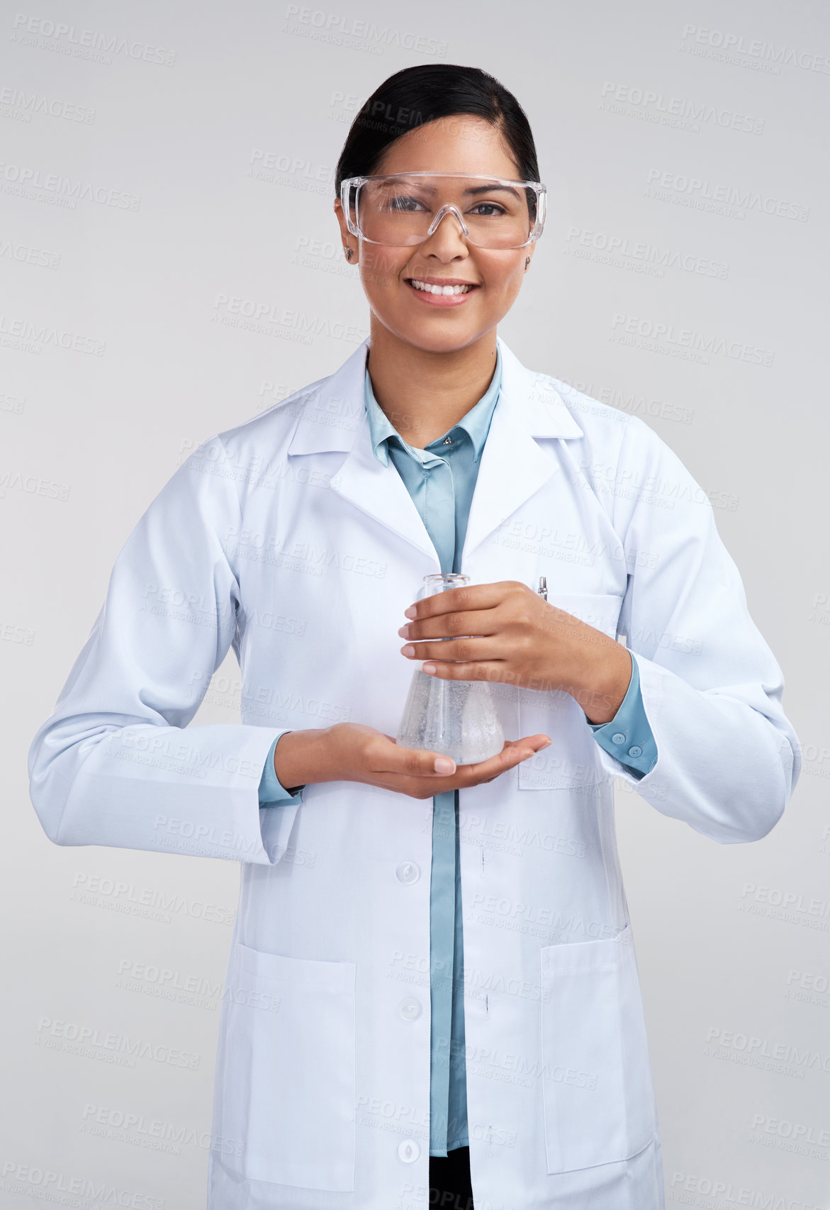 Buy stock photo Cropped portrait of an attractive young female scientist holding a beaker filled with liquid in studio against a grey background