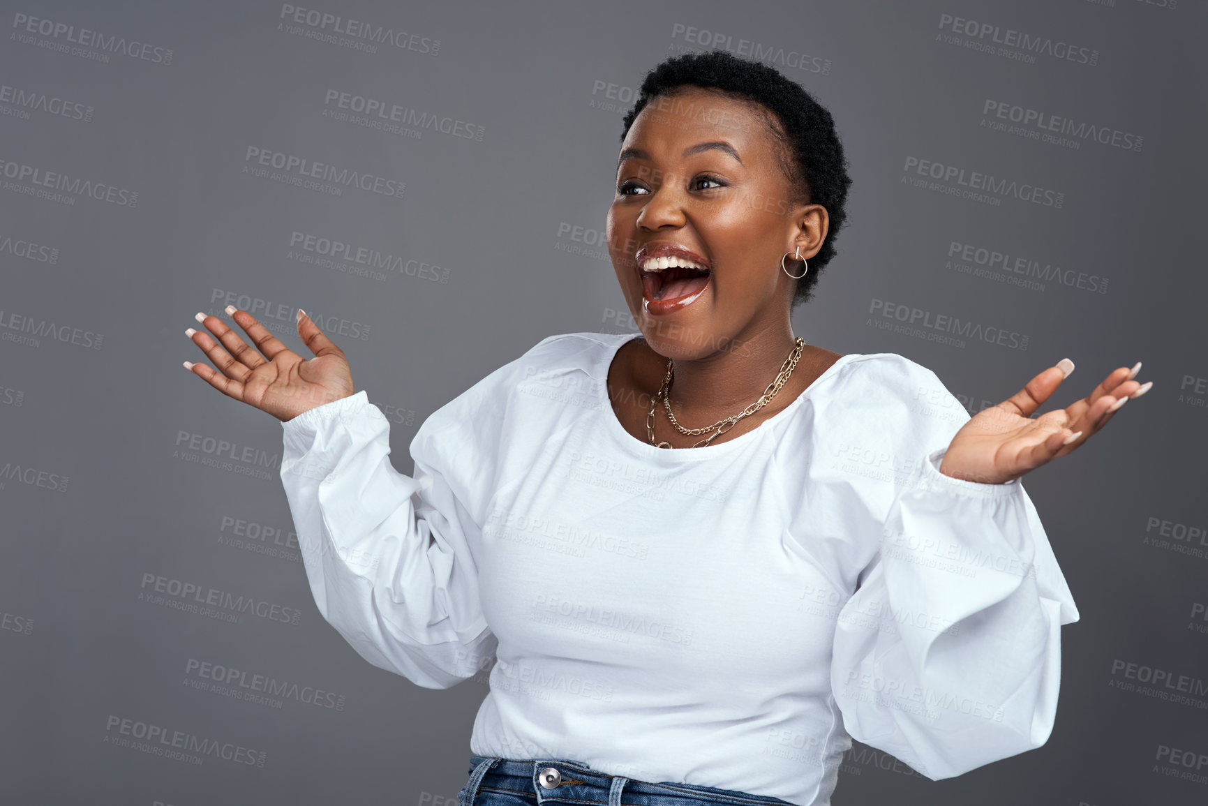 Buy stock photo Shot of a young woman holding up her hands while standing against a grey background