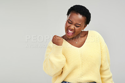 Buy stock photo Shot of a young woman looking cheerful while posing against a grey background