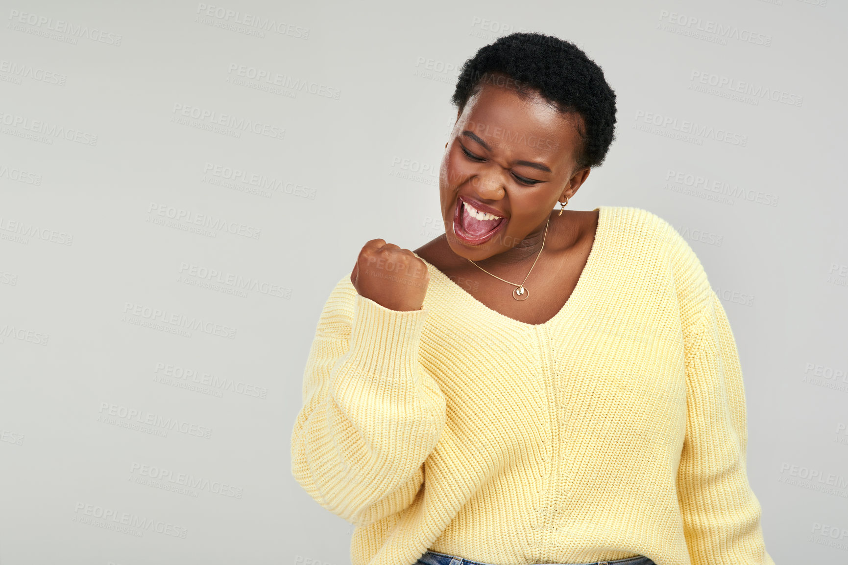 Buy stock photo Shot of a young woman looking cheerful while posing against a grey background