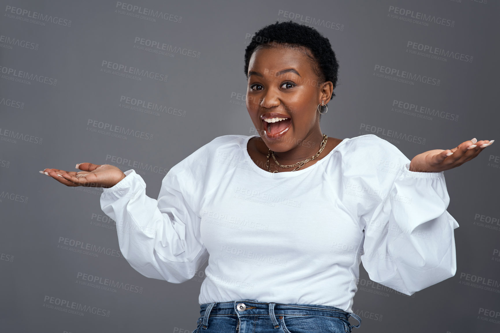 Buy stock photo Shot of a young woman holding up her hands while standing against a grey background