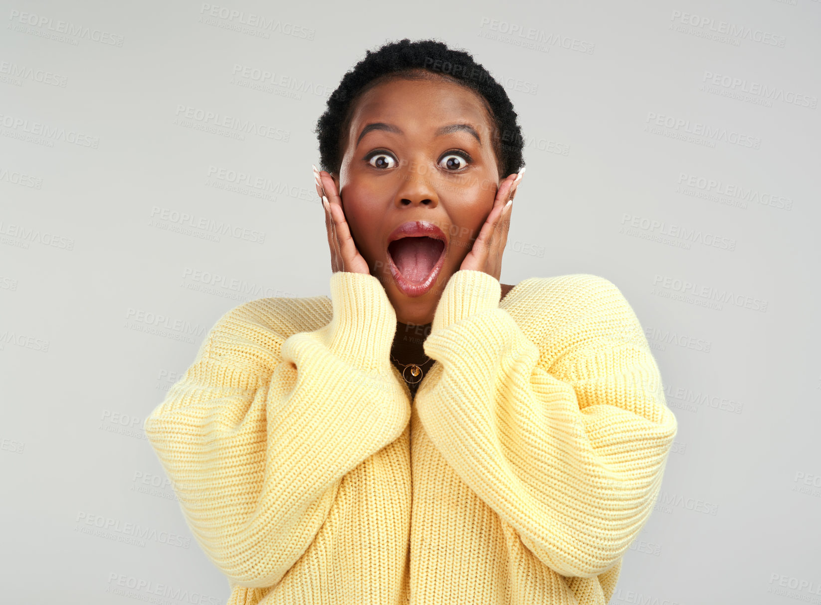 Buy stock photo Shot of a young woman looking surprised while posing against a grey background