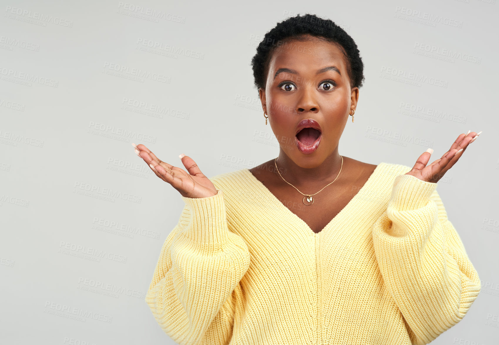 Buy stock photo Shot of a young woman looking surprised while posing against a grey background