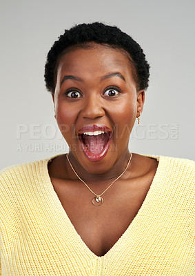 Buy stock photo Shot of a young woman looking surprised while posing against a grey background