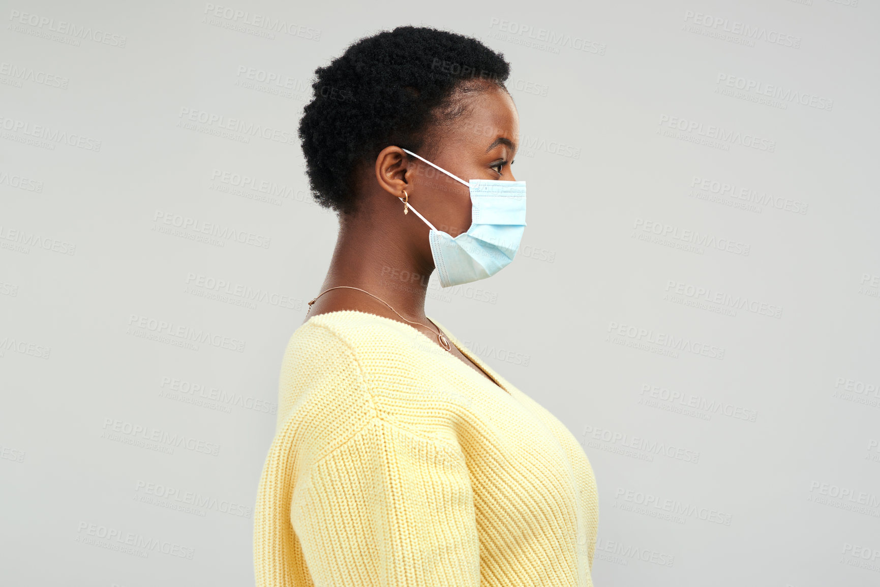 Buy stock photo Shot of a young woman wearing a surgical mask while standing against a grey background