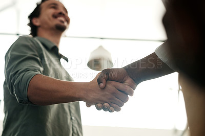 Buy stock photo Shot of a two unrecognizable businessmen standing in the office together and shaking hands
