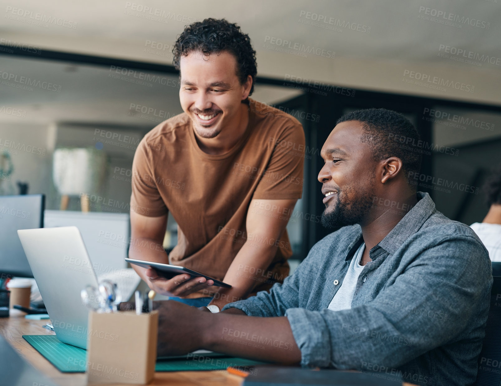 Buy stock photo Shot of two young businessmen working together in an office