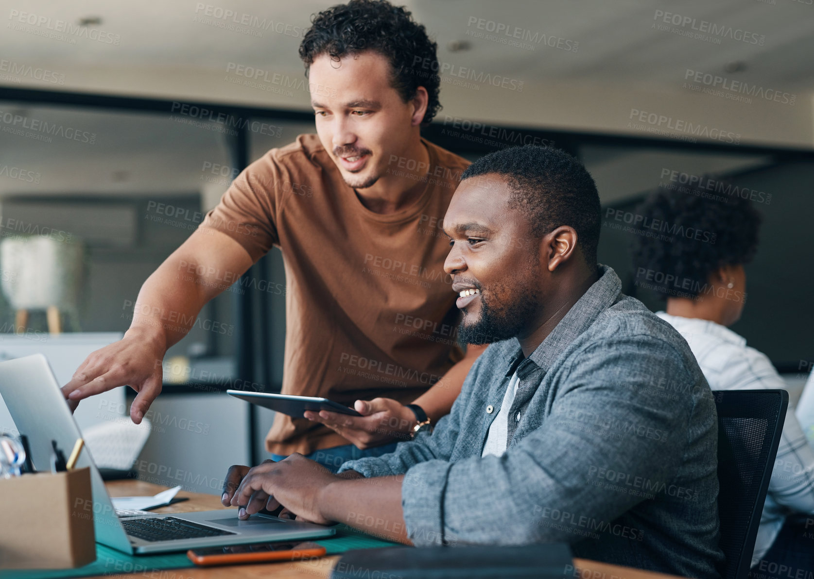 Buy stock photo Shot of two young businessmen working together in an office