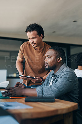 Buy stock photo Shot of two young businessmen working together in an office