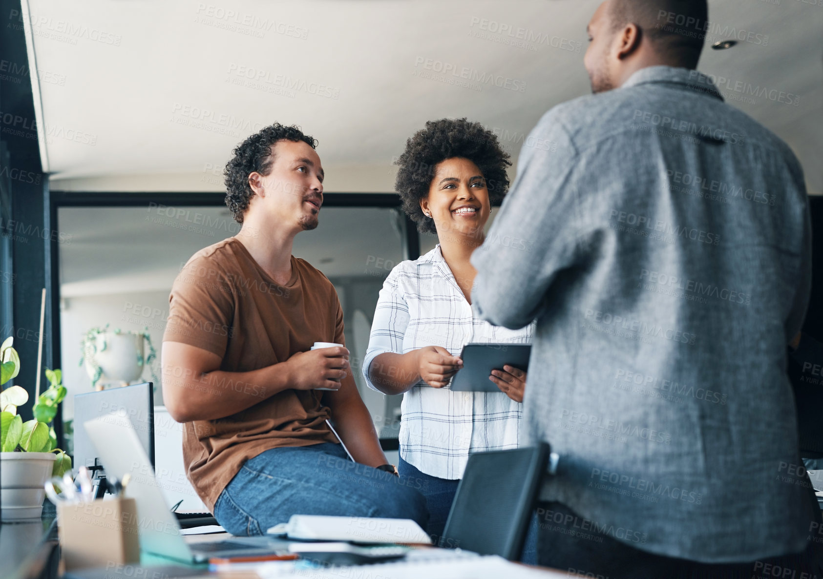 Buy stock photo Shot of a group of young businesspeople talking in an office