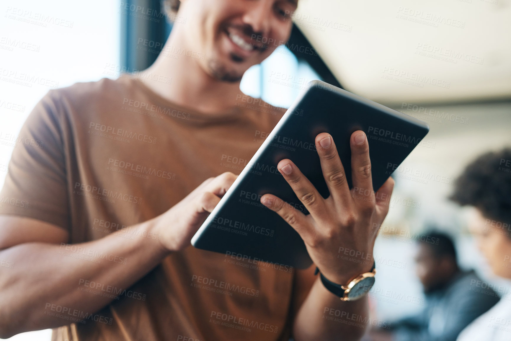 Buy stock photo Shot of a young businessman using a digital tablet in an office