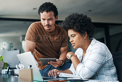 Buy stock photo Shot of two young businesspeople working together in an office