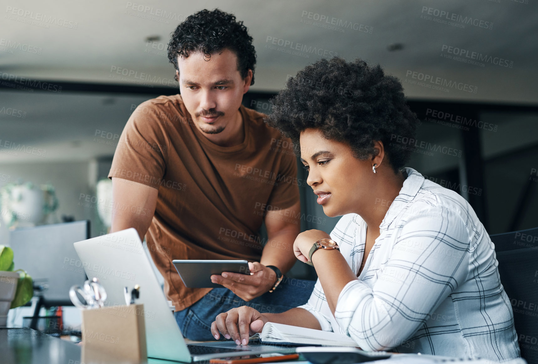 Buy stock photo Shot of two young businesspeople working together in an office