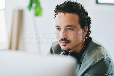 Buy stock photo Shot of a young businessman using a computer in an office