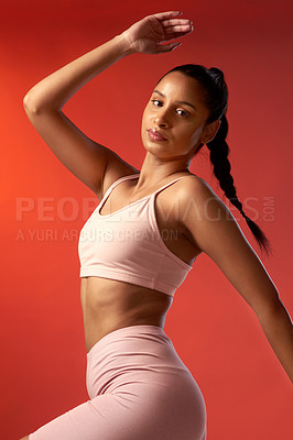 Buy stock photo Studio portrait of a sporty young woman posing against a red background