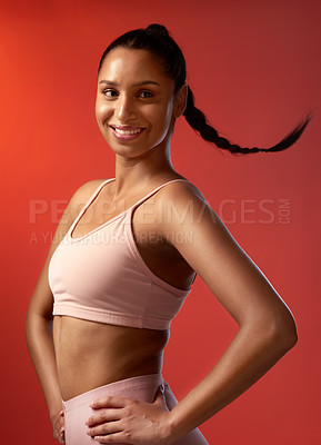 Buy stock photo Studio shot of a sporty young woman posing against a red background