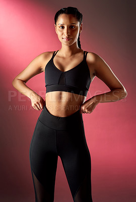 Buy stock photo Studio portrait of a sporty young woman posing against a red background