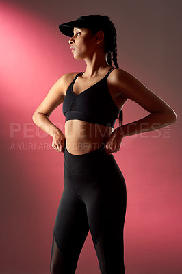 Buy stock photo Studio shot of a sporty young woman posing against a red background