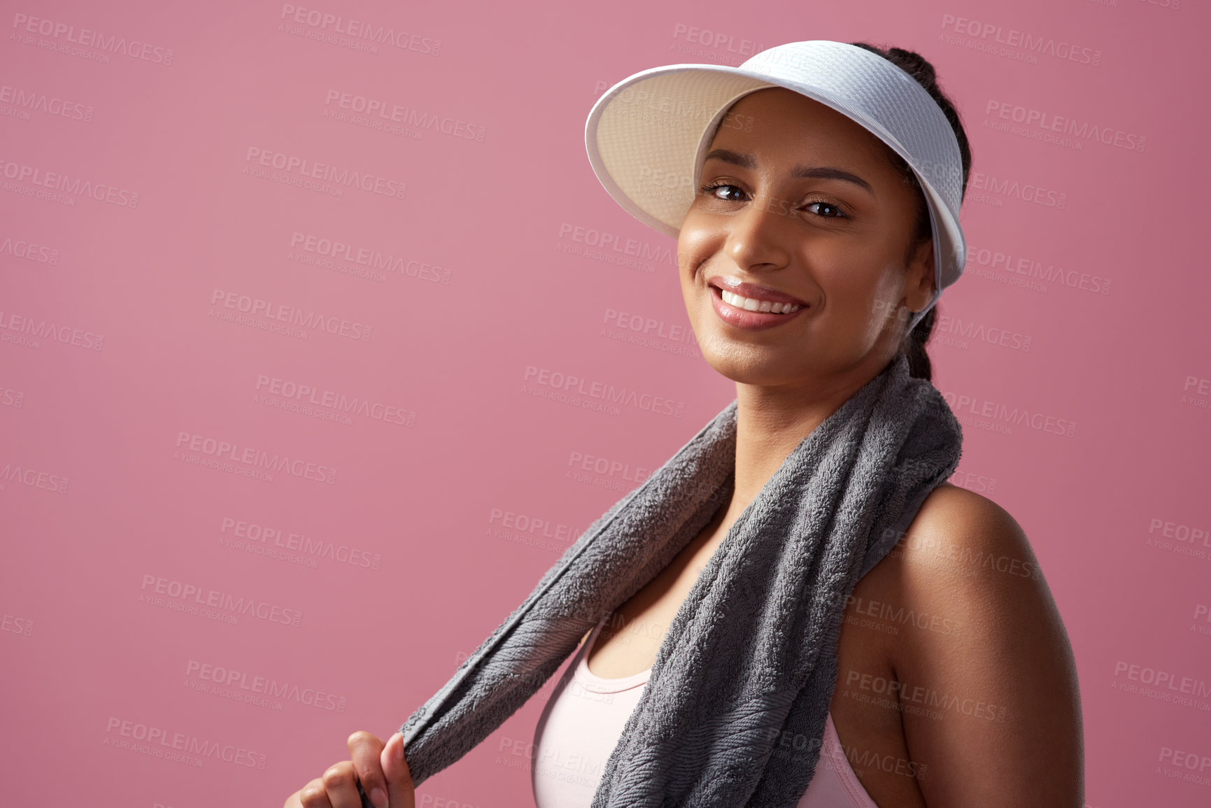 Buy stock photo Cropped portrait of an attractive and sporty young woman posing with a towel in studio against a pink background