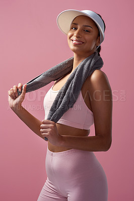 Buy stock photo Cropped portrait of an attractive and sporty young woman posing with a towel in studio against a pink background