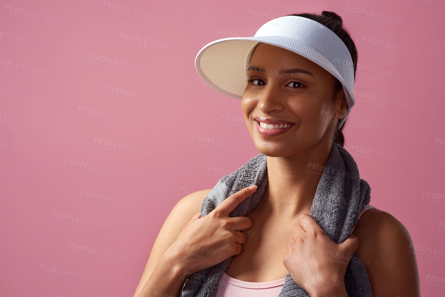 Buy stock photo Cropped portrait of an attractive and sporty young woman posing with a towel in studio against a pink background