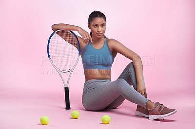Buy stock photo Full length portrait of an attractive and sporty young woman posing with a tennis racket and tennis balls in studio against a pink background