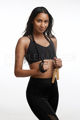 Buy stock photo Studio portrait of a sporty young woman posing with a skipping rope around her neck against a white background