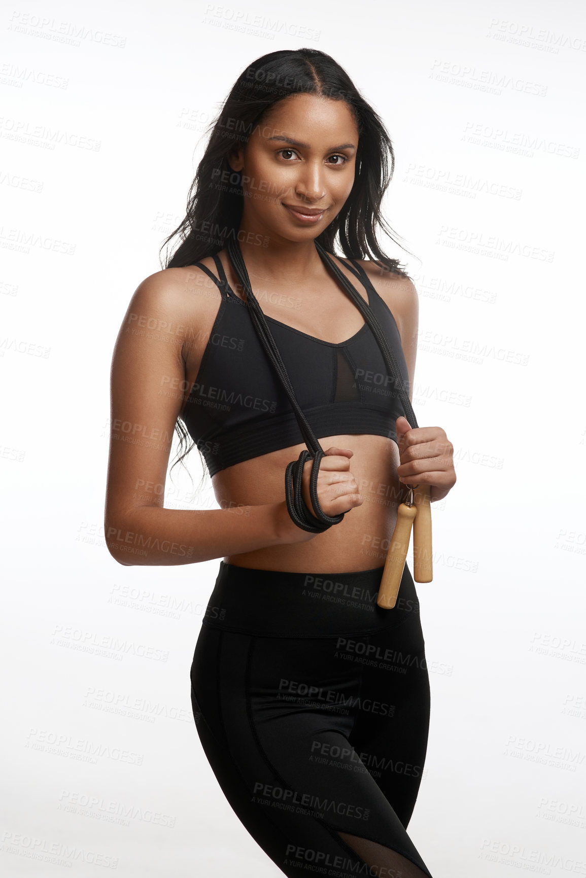 Buy stock photo Studio portrait of a sporty young woman posing with a skipping rope around her neck against a white background