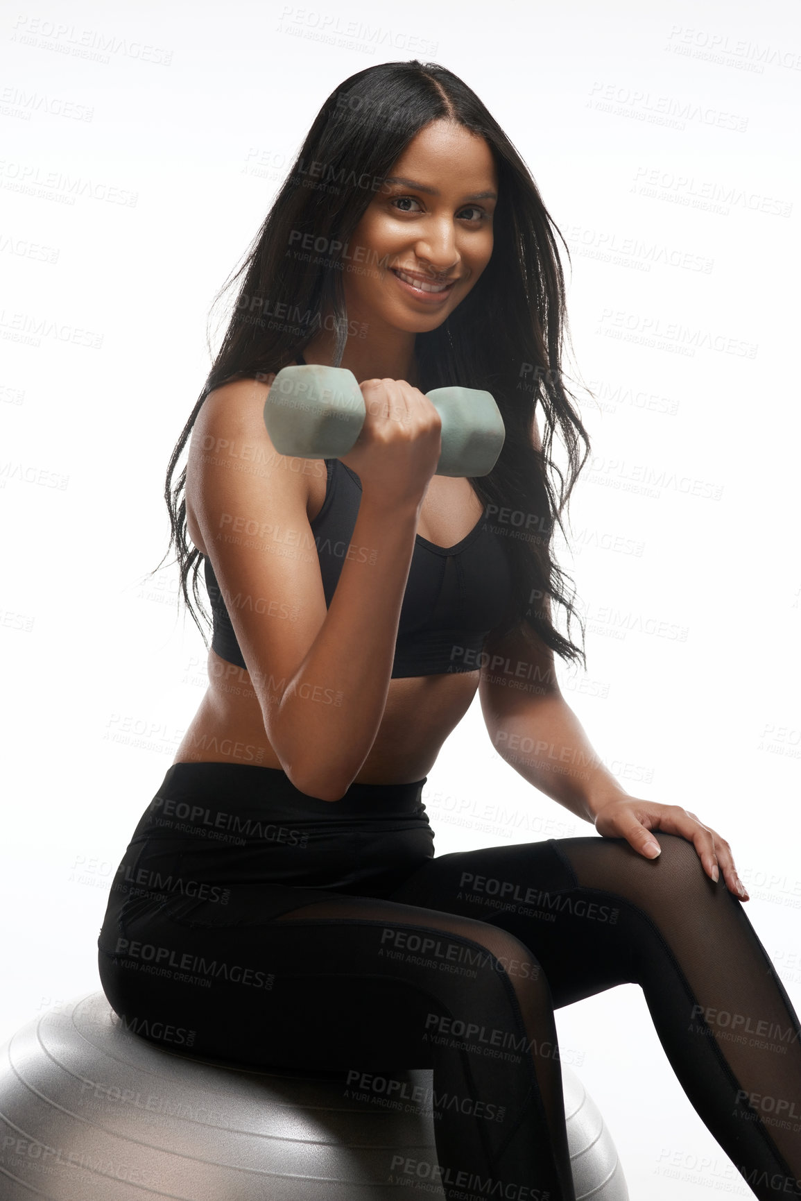 Buy stock photo Studio portrait of a sporty young woman exercising with a dumbbell against a white background