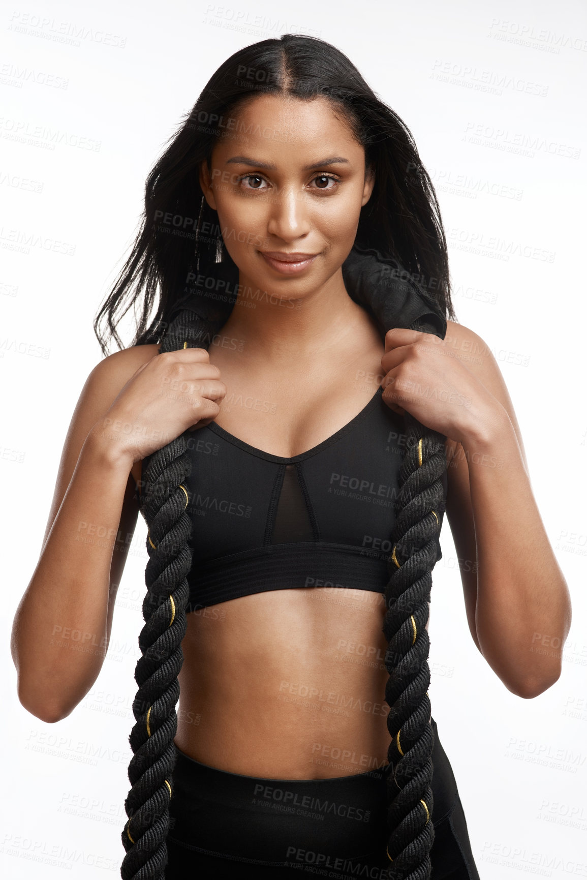 Buy stock photo Studio portrait of a sporty young woman posing with battle ropes around her neck against a white background