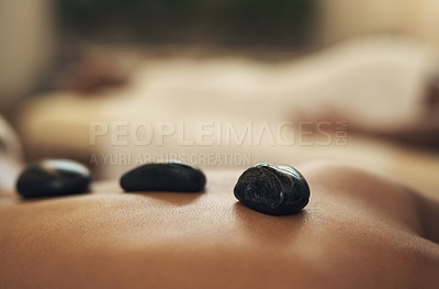 Buy stock photo Cropped shot of a woman getting a hot stone massage at a spa