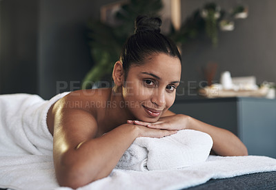 Buy stock photo Portrait of a young woman lying on a massage bed at a spa