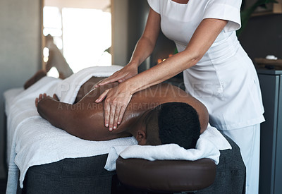 Buy stock photo Shot of a young man getting a back massage at a spa