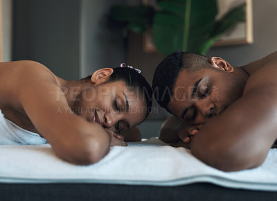 Buy stock photo Shot of a young couple relaxing on massage beds at a spa