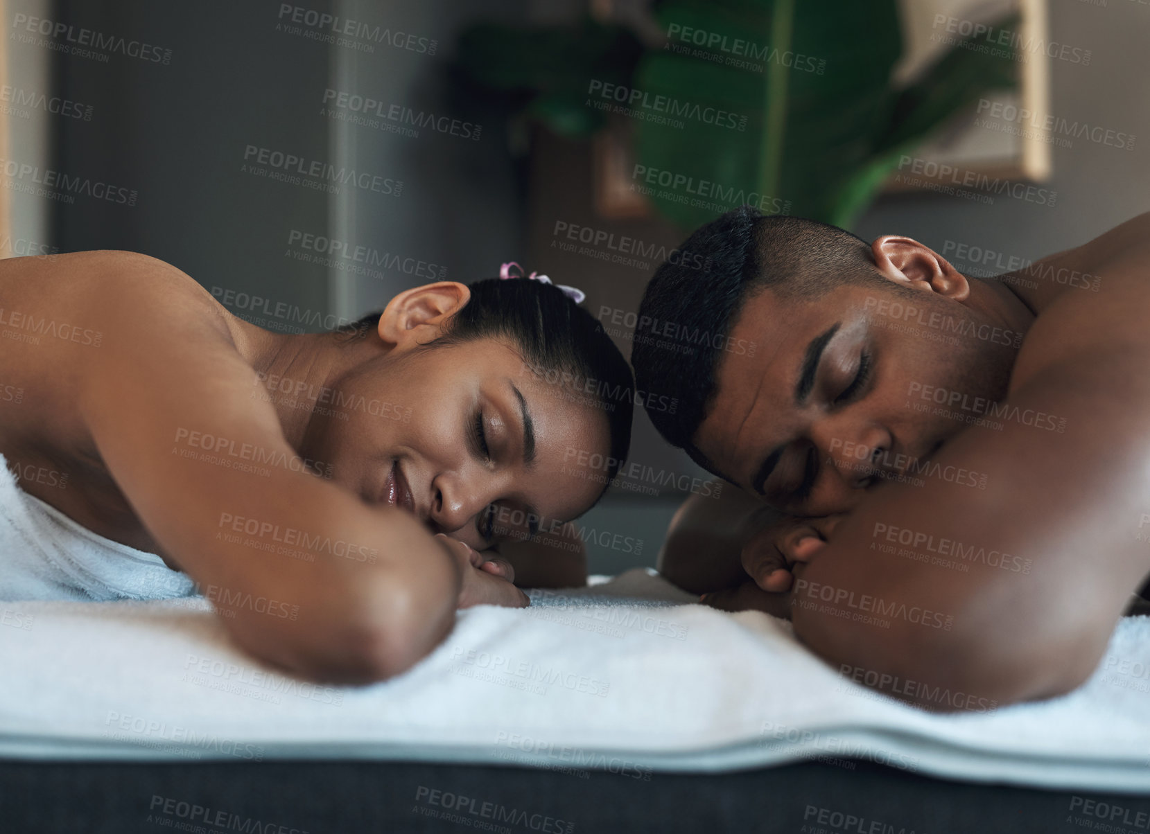 Buy stock photo Shot of a young couple relaxing on massage beds at a spa