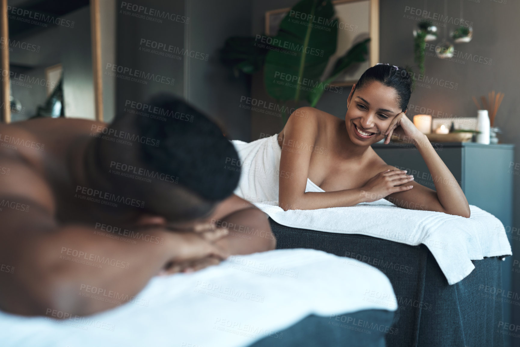 Buy stock photo Shot of a young couple relaxing on massage beds at a spa