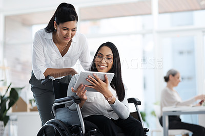 Buy stock photo Cropped shot of an attract young businesswoman in a wheelchair talking to the female colleague pushing her through the office