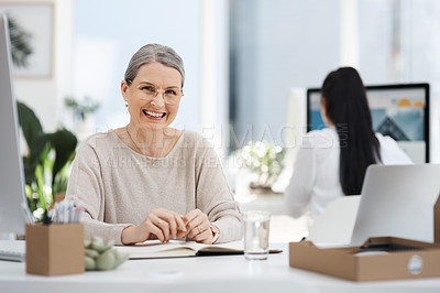 Buy stock photo Cropped portrait of an attractive mature businesswoman smiling while working at her desk in the office