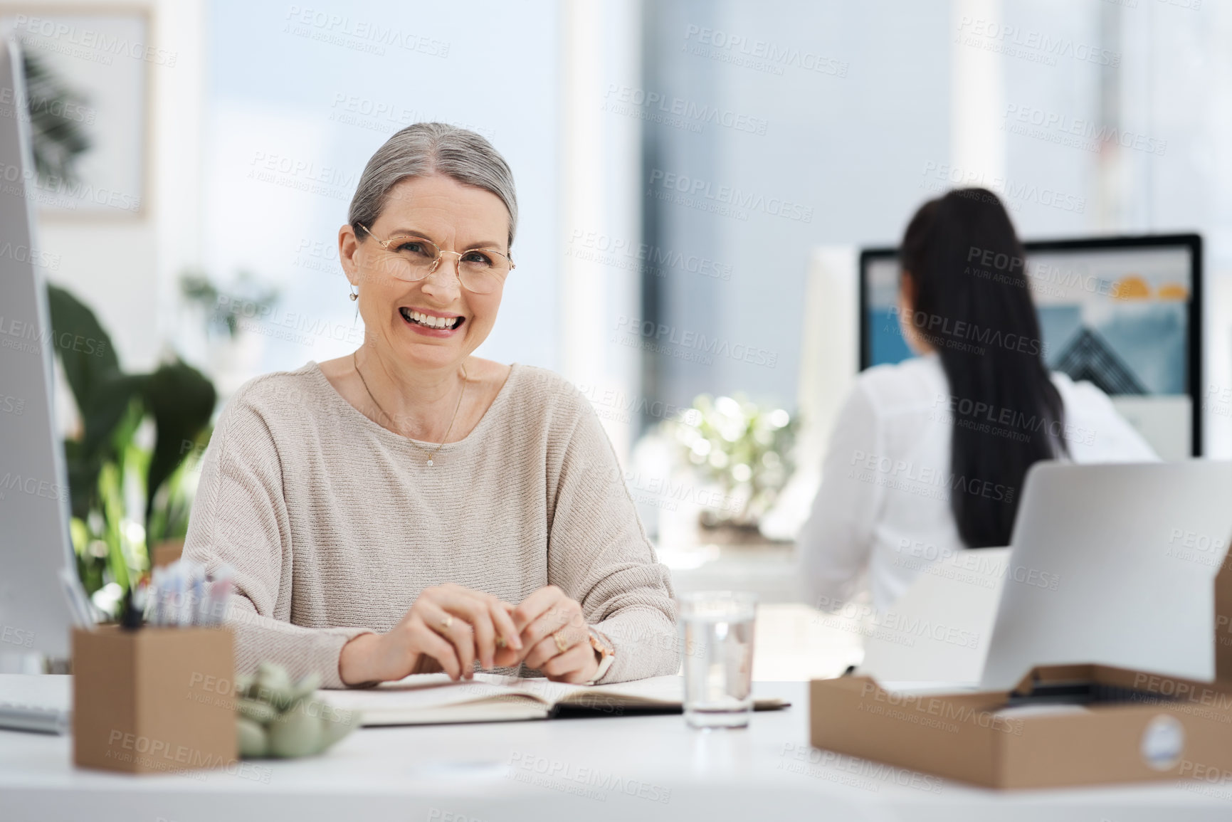 Buy stock photo Cropped portrait of an attractive mature businesswoman smiling while working at her desk in the office