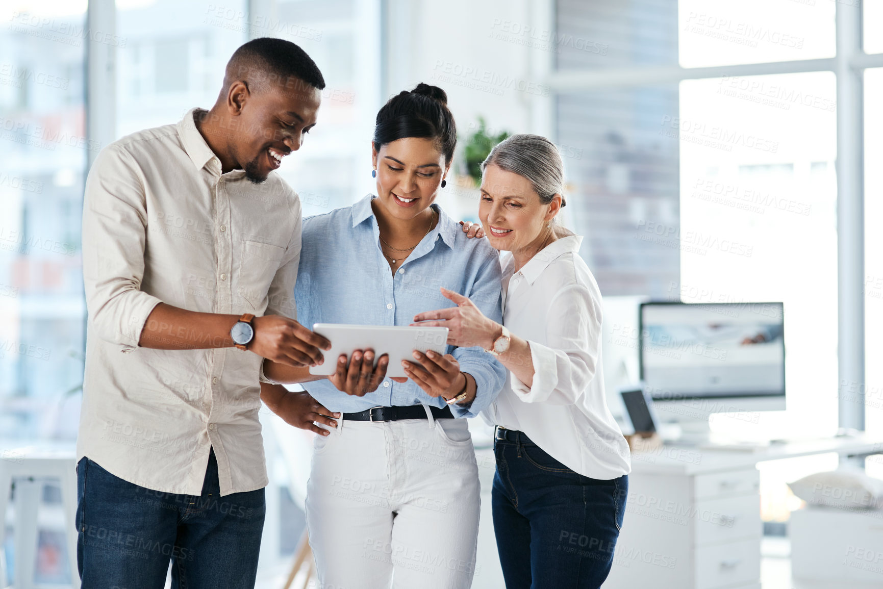 Buy stock photo Shot of a group of businesspeople using a digital tablet together in an office