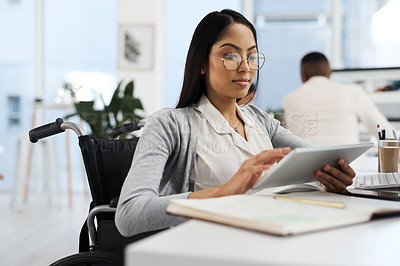 Buy stock photo Cropped shot of an attractive young businesswoman working on a tablet at her desk in the office