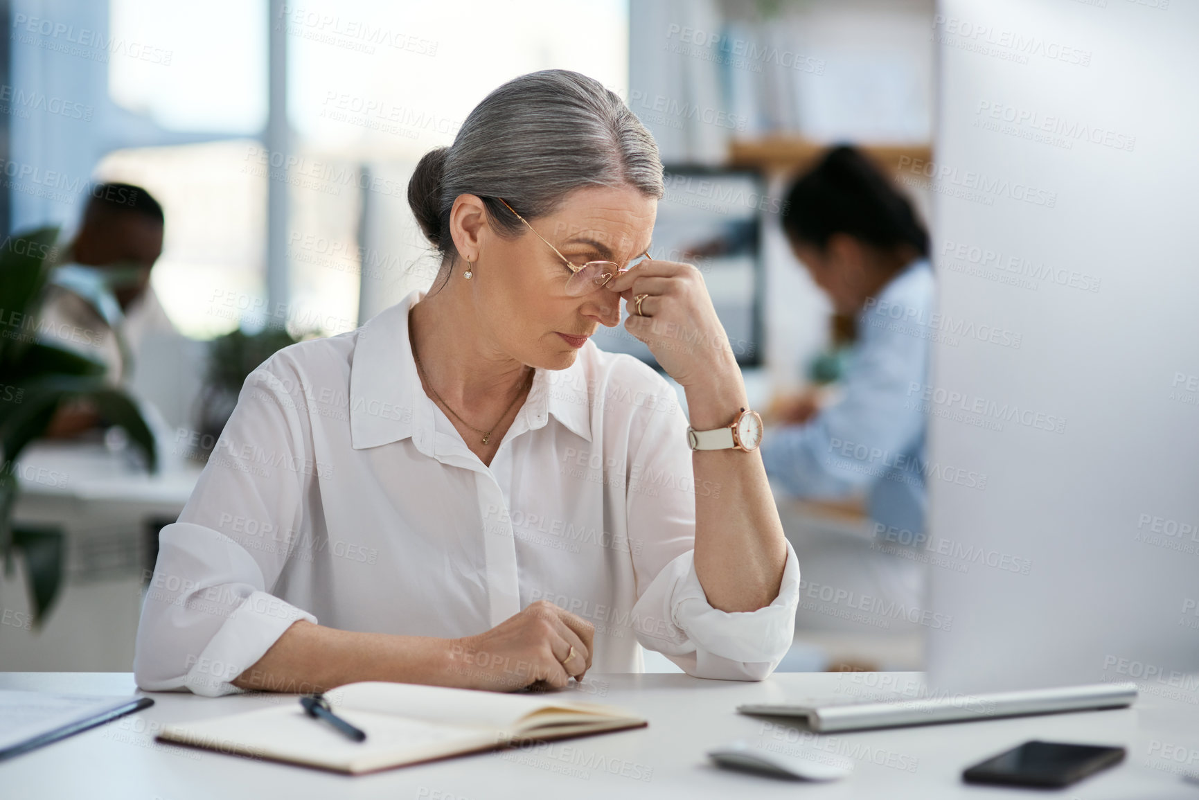 Buy stock photo Shot of a mature businesswoman looking stressed out while working in an office