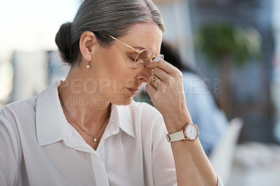 Buy stock photo Shot of a mature businesswoman looking stressed out while working in an office