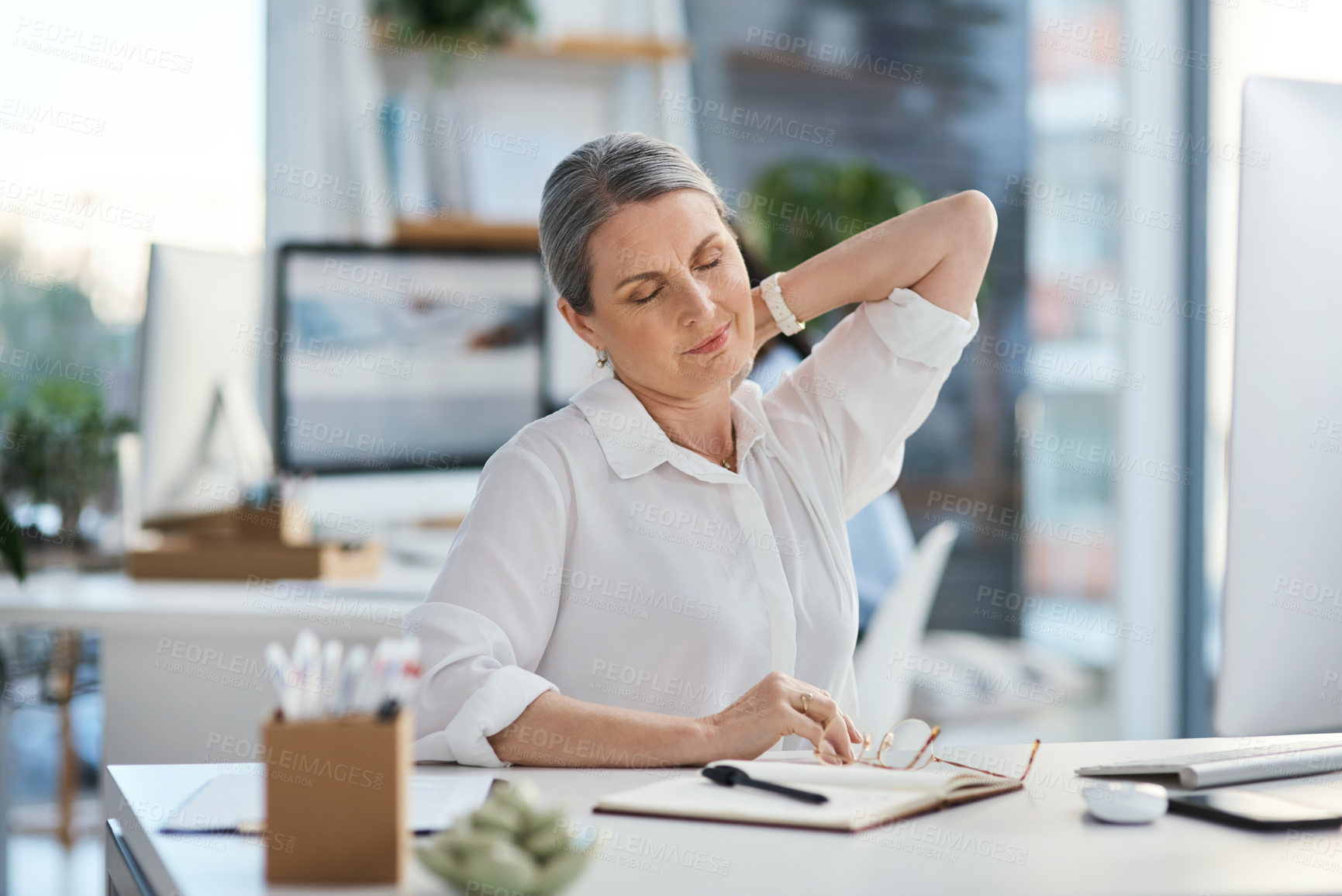 Buy stock photo Shot of a mature businesswoman experiencing neck pain while working in an office