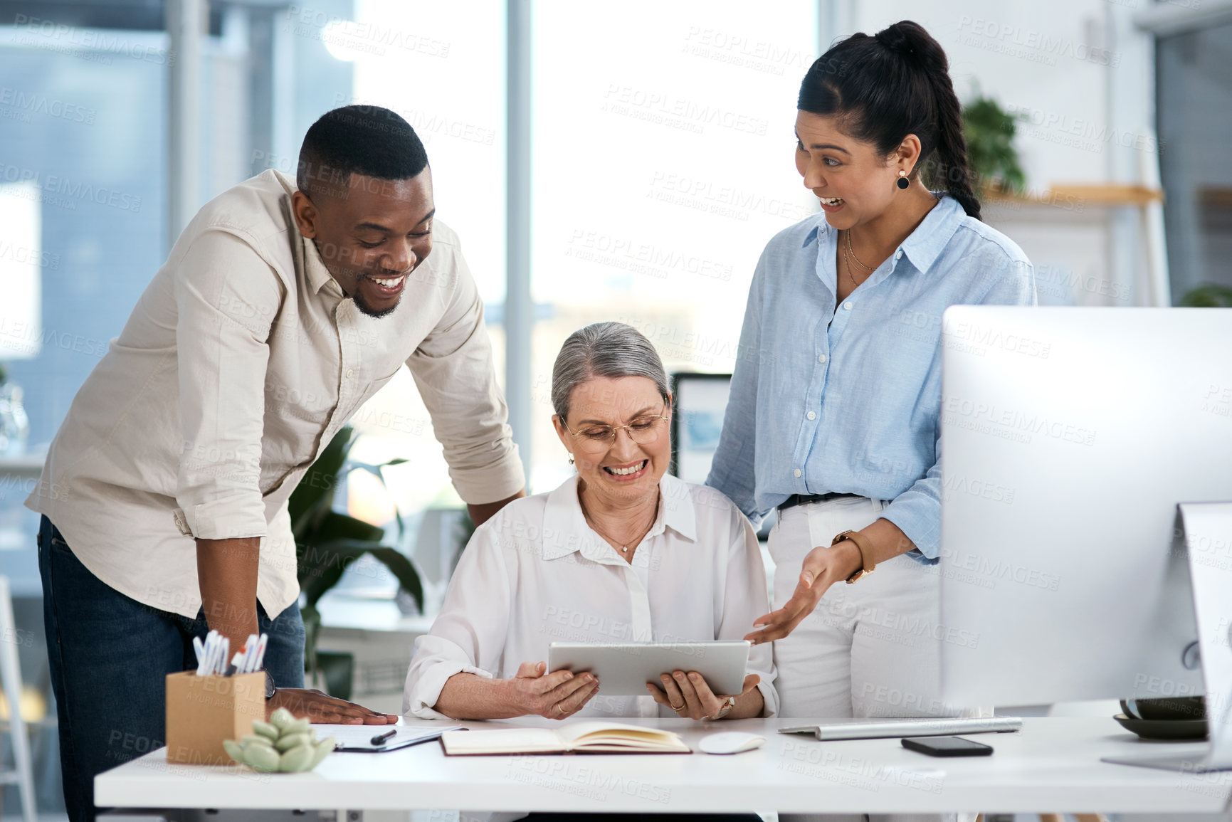 Buy stock photo Shot of a group of businesspeople using a digital tablet together in an office