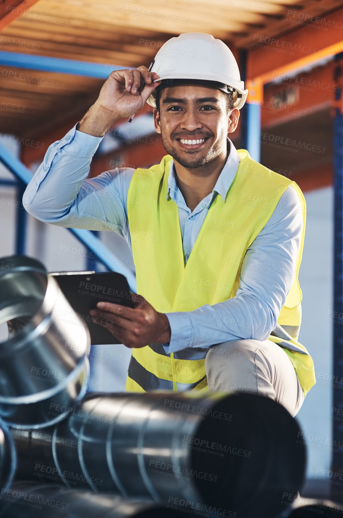 Buy stock photo Shot of a handsome young contractor crouching down and doing a stock-take in the warehouse