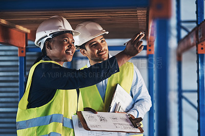 Buy stock photo Shot of two young contractors standing together and examining the scaffolding in the warehouse