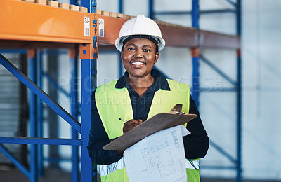 Buy stock photo Shot of an attractive young contractor standing in the warehouse and holding a clipboard